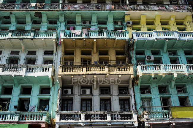 Low angle view of facade of old apartment building, rows of balconies and windows. — Stock Photo