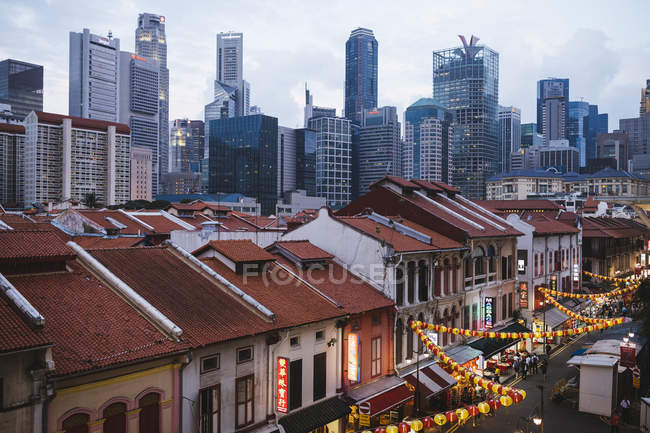 Vista ad alto angolo di vecchi negozi di Chinatown e moderni grattacieli di Singapore al tramonto . — Foto stock