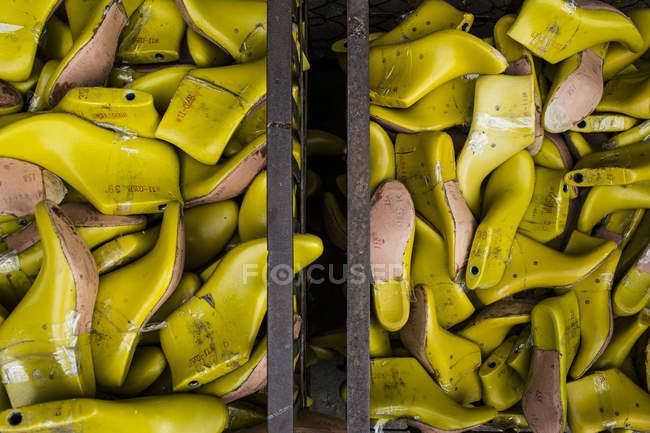 Primo piano ad alto angolo di contenitori di stampi per scarpe gialli in una fabbrica . — Foto stock