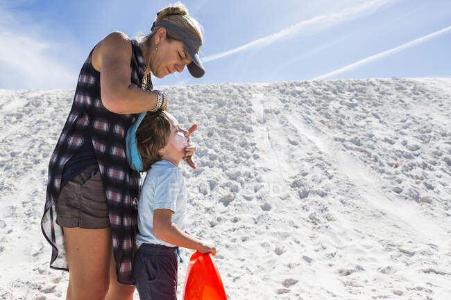 Mãe aplicando protetor solar para seu filho — Fotografia de Stock