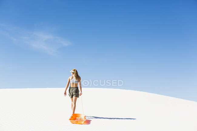 13 year old girl pulling sled in White Sands Nat'l Monument NM — Stock Photo