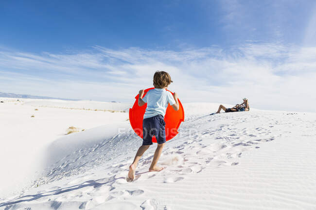 6 year old boy climbing sand dune — Stock Photo