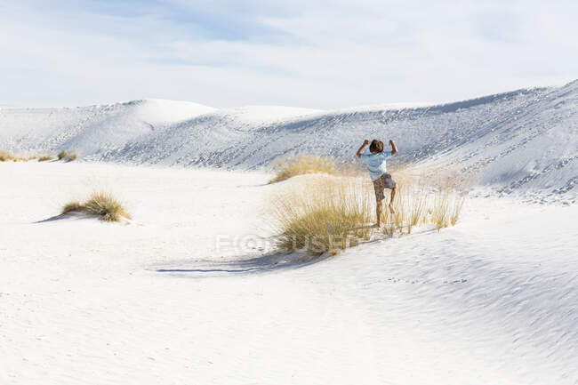 6-летний мальчик, играющий в песчаных дюнах, памятник Белым пескам Натал, шт. Нью-Мексико — стоковое фото