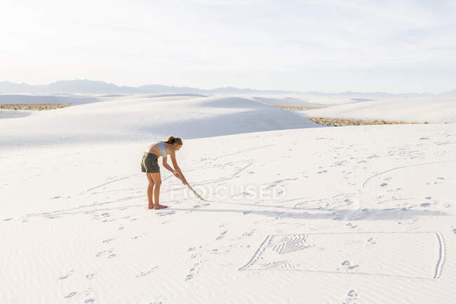 13-jähriges Mädchen zeichnet im Sand, White Sands National Monument, NM — Stockfoto