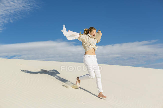 13 anni ragazza saltando e ballando in sabbia bianca chiara in un paesaggio dune. — Foto stock