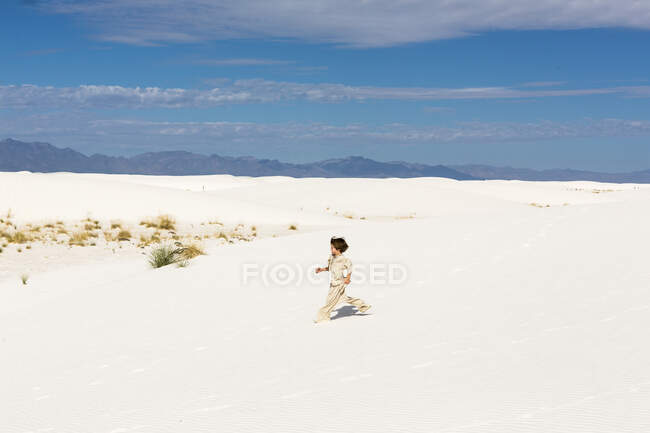 Ragazzo di 6 anni che cammina in dune di sabbia bianca. — Foto stock