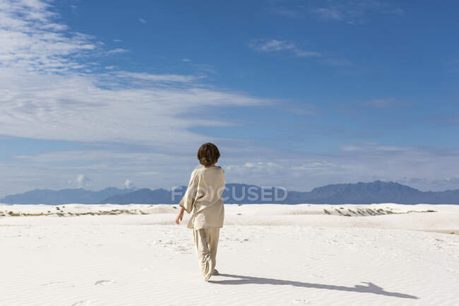 6 anno vecchio ragazzo camminare in sabbia dnes. — Foto stock
