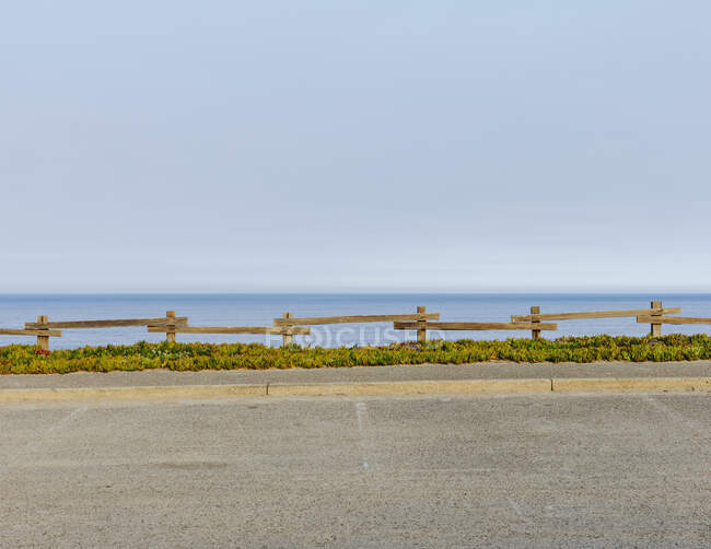 Parking lot with fencing and ice plant ground cover, by the ocean — Stock Photo