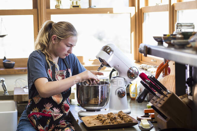 Adolescente de 13 ans utilisant un mélangeur dans la cuisine. — Photo de stock
