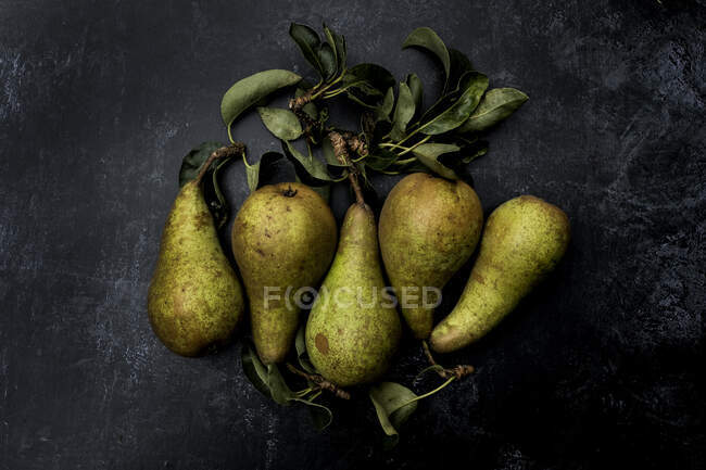 High angle close up of green pears on black background. — Stock Photo