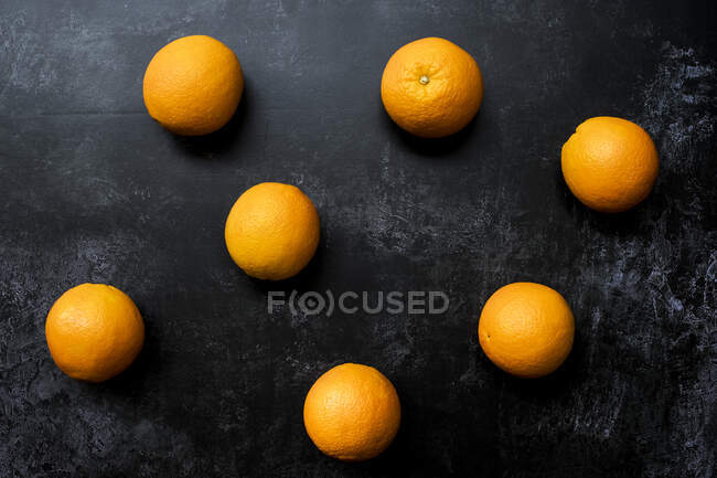 Alto ángulo de cerca de naranjas sobre fondo negro . - foto de stock