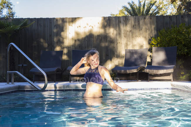 Niña de 13 años nadando en una piscina. - foto de stock