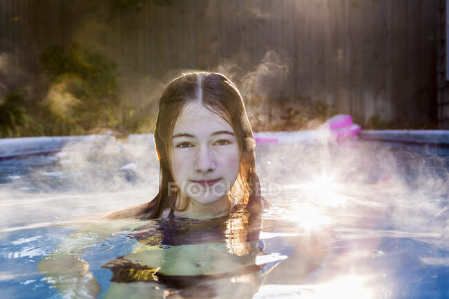 Jeune fille de 13 ans nageant dans une piscine — Photo de stock