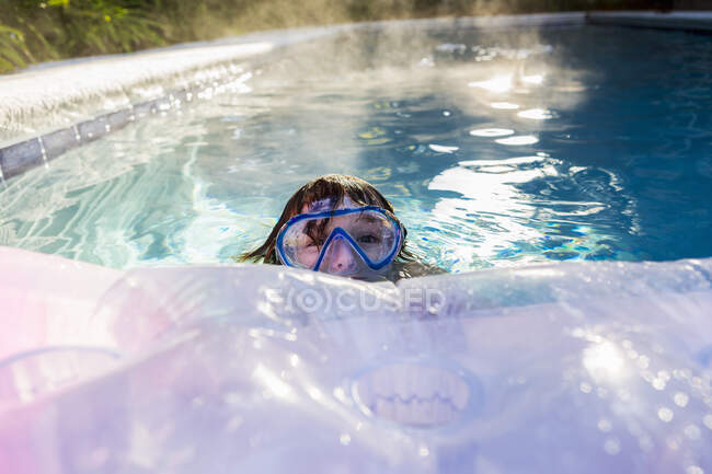 Шестирічний хлопчик грає в опалювальному басейні — стокове фото