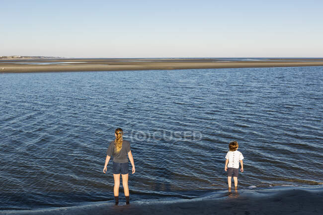 Visão traseira de crianças que olham para o oceano — Fotografia de Stock