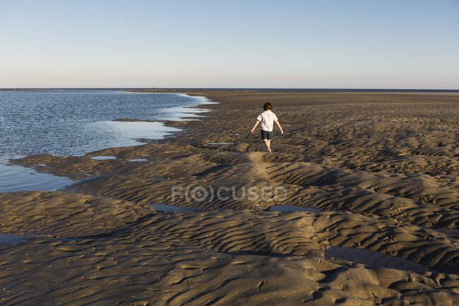 Un garçon de six ans examine un paysage sablonneux — Photo de stock
