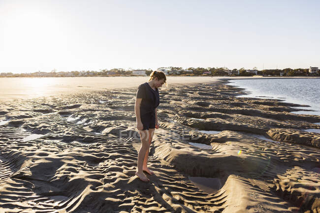 Дівчина-підліток грає в піщаних дюнах, на пляжі — стокове фото
