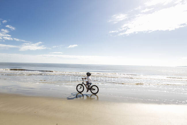 Jeune garçon de 6 ans à vélo sur la plage, île St. Simon, Georgie — Photo de stock