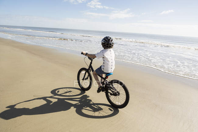 Jeune garçon de 6 ans à vélo sur la plage, île St. Simon, Georgie — Photo de stock