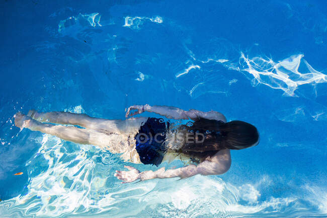 Adolescente ragazza nuoto in una piscina, vista dall'alto. — Foto stock