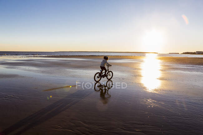 Boy riding a bicycle on the beach, St. Simons Island, Georgia — Stock Photo