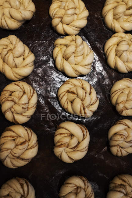 High angle close up of tray with cinnamon buns in an artisan bakery. — Stock Photo