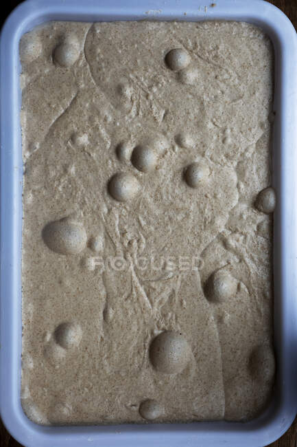 Alto angolo di chiusura della pasta di pane con bolle d'aria in una panetteria artigianale . — Foto stock