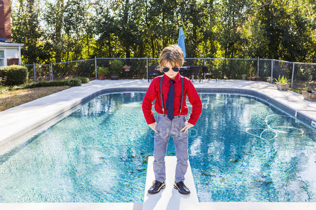 6 anos de idade menino de pé na placa de mergulho com vista para a piscina — Fotografia de Stock