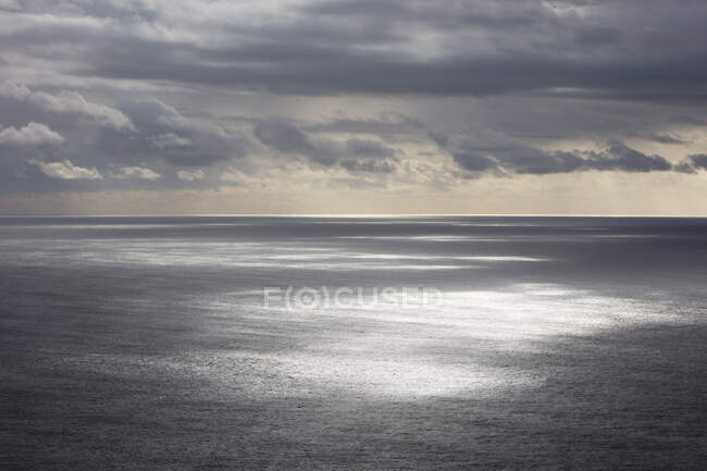 Gewitterwolken, die über dem weiten Ozean aufziehen, gesprenkeltes Sonnenlicht auf dem Wasser, nördliche Küste von Oregon — Stockfoto