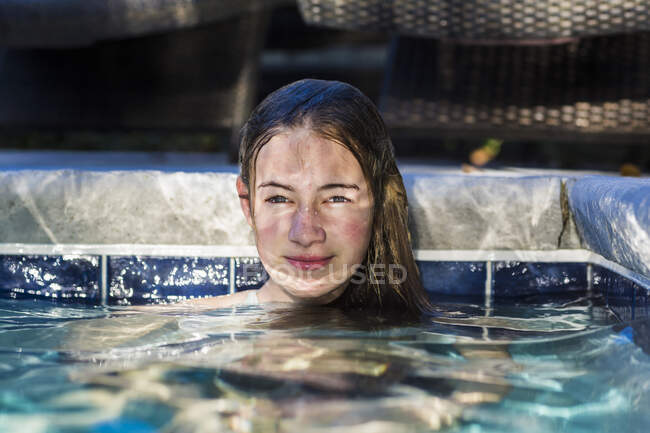 13-летняя девочка в бассейне, на лице которой играет Мбаппе — стоковое фото