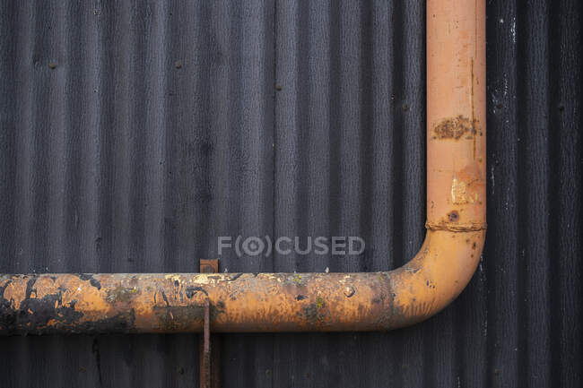 Orange gutter drain pipe against warehouse wall, close up — Stock Photo