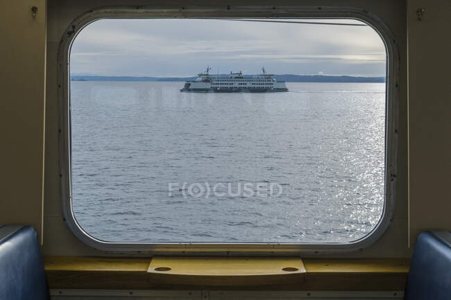 Vista al otro lado del agua desde la ventana de un ferry, un ferry en Puget Sound - foto de stock