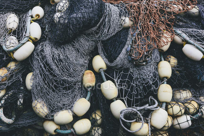 Mucchio di reti da pesca commerciali e reti da imbrocco su una banchina da pesca, primo piano — Foto stock
