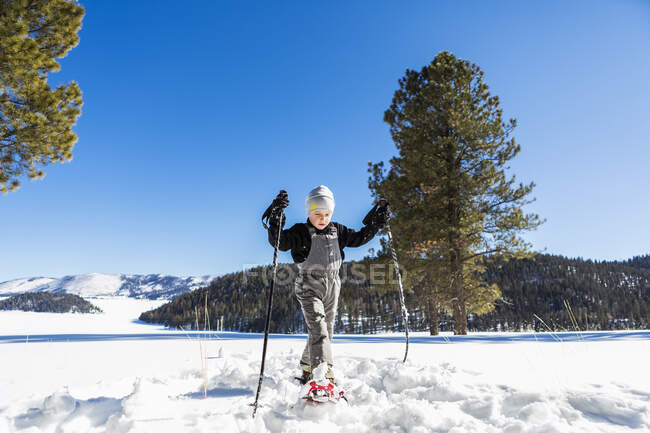 Sechsjähriger Junge mit Schneeschuhen und Skistöcken — Stockfoto