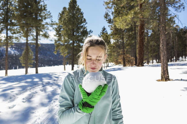 Blondes Teenager-Mädchen hält einen Schneeball in der Hand — Stockfoto