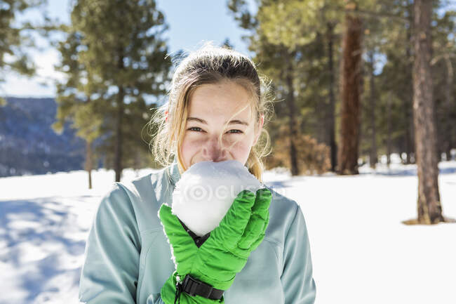 Teenage girl old girl holding and tasting a snowball — Stock Photo