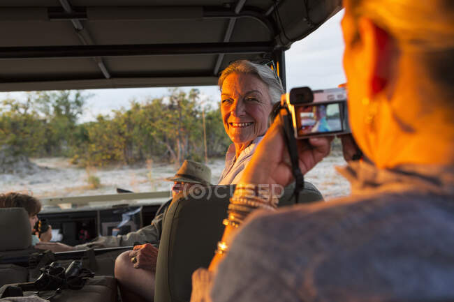 Mujer mayor en un vehículo girando y sonriendo para la cámara. - foto de stock
