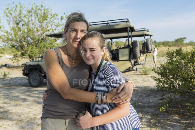 Madre e hija abrazándose y sonriendo a la cámara, África del Sur - foto de stock