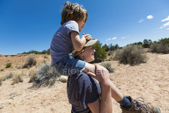 Menina de 14 anos dando a um irmão mais novo um passeio de piggyback, Galisteo Basin, NM. — Fotografia de Stock
