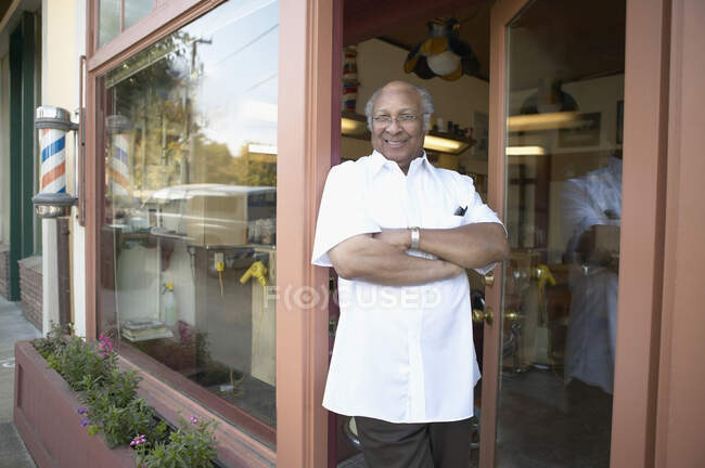 Barber standing in doorway and smiling at camera — Stock Photo