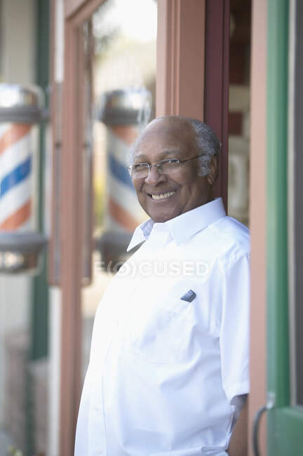 Barber standing in doorway and smiling at camera — Stock Photo