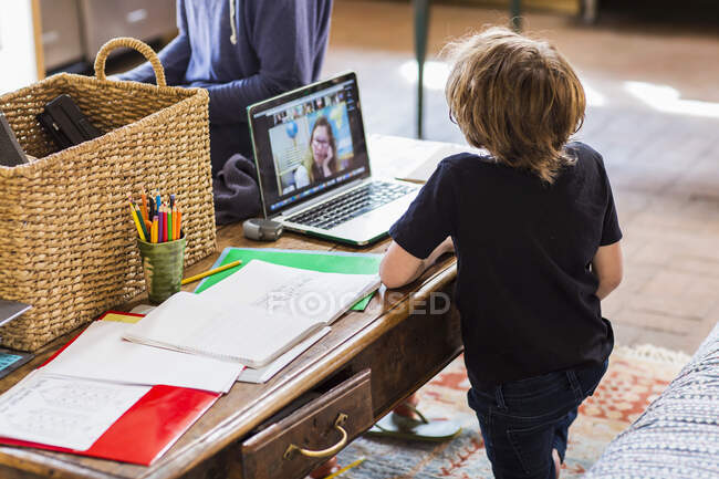 Un enfant travaillant à la maison, leçons en ligne pendant le confinement — Photo de stock