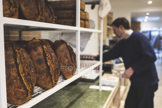 Handwerkliche Bäckerei, die spezielles Sauerteigbrot herstellt, Regale mit gekochten Broten. — Stockfoto