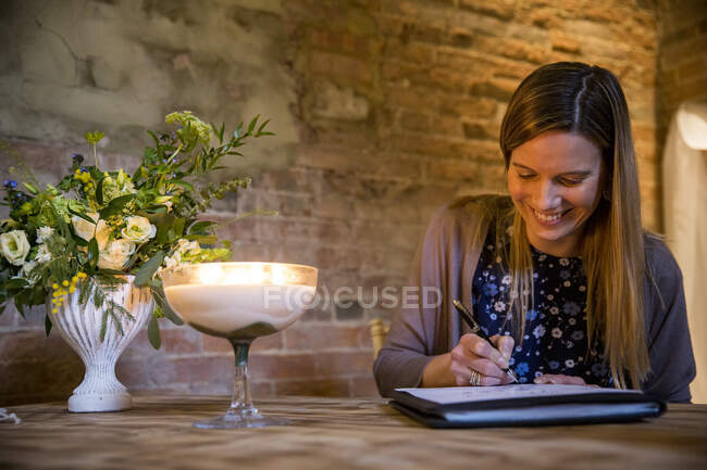 Witness signing certificate during naming ceremony in an historic barn. — Stock Photo