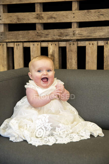 Portrait de bébé fille en robe blanche lors de la cérémonie de désignation dans une grange historique. — Photo de stock