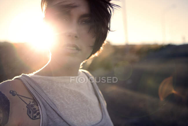 Eine junge Frau steht bei Sonnenuntergang im Freien. — Stockfoto