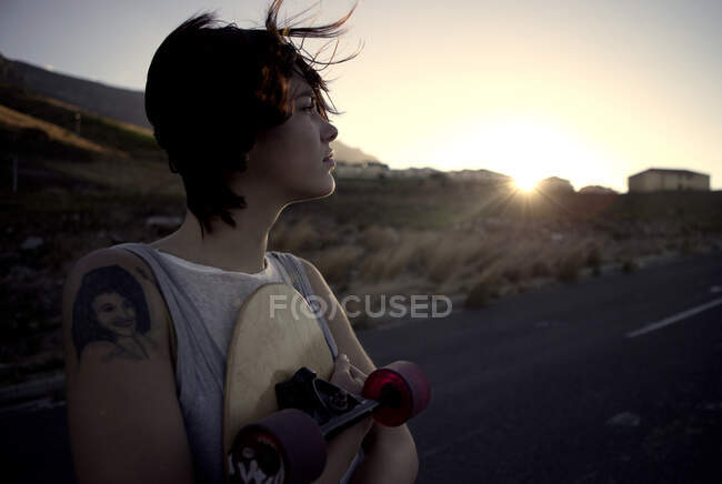 Молода жінка тримає скейтборд . — стокове фото