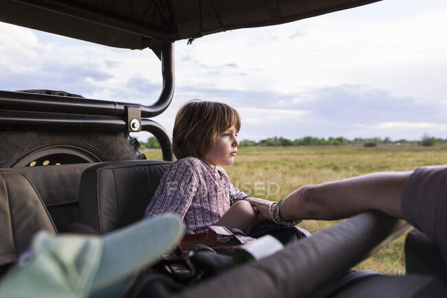 Un bambino di cinque anni in safari, in un veicolo in una riserva di caccia — Foto stock