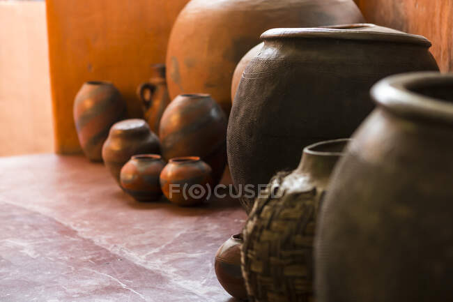 Ceramiche tradizionali, un gruppo di vasi e zucche su un pavimento piastrellato. — Foto stock