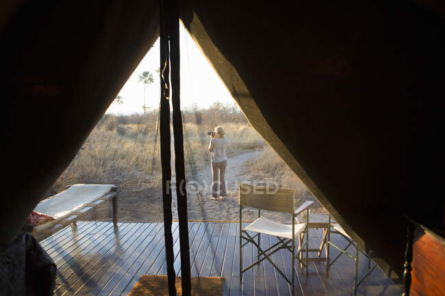 Femme prenant une photo au crépuscule, dans le désert du Kalahari. — Photo de stock